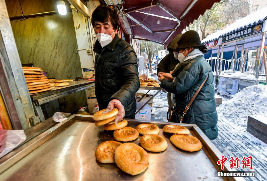 烏魯木齊市文化路，已開門營業(yè)的馕店吸引過往市民前來購買。 劉新 攝